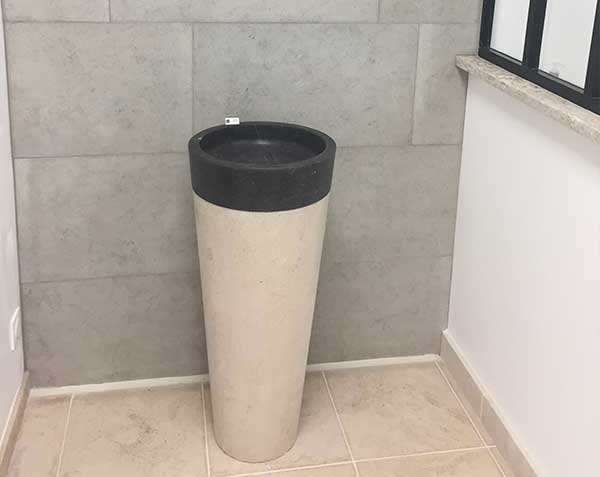 Pedestal basin in front of a stone wall covering in Softened Bleu de Lignières